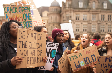 Young people holding signs protest climate change inaction