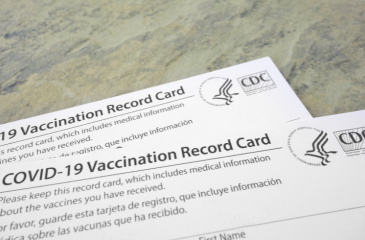 Two CDC COVID-19 Vaccination cards on a table