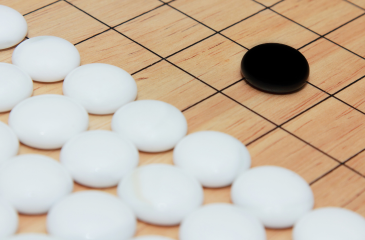 Image of a black checker facing off a team of all white checkers