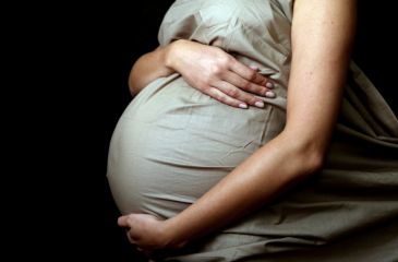 Woman pregnant holding stomach