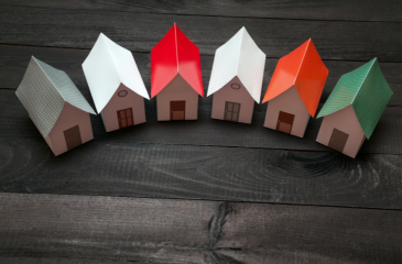 Six cut out houses in semi circle on wooden floor